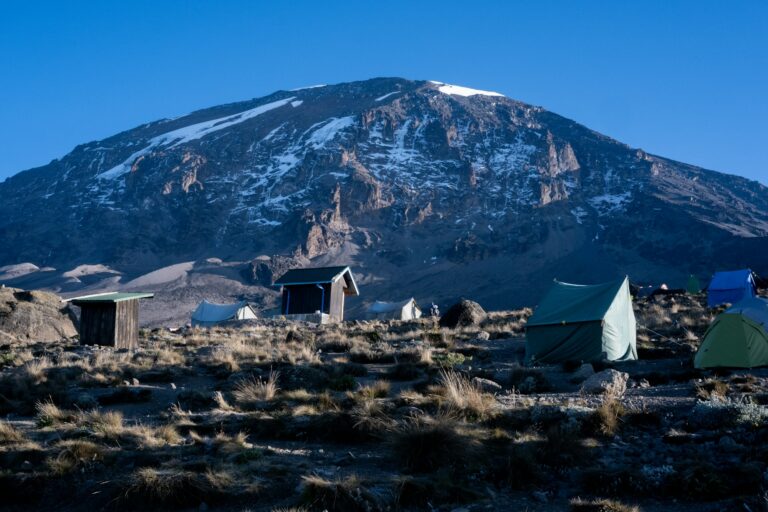 Tents at a Kilimanjaro camp under a blue sky