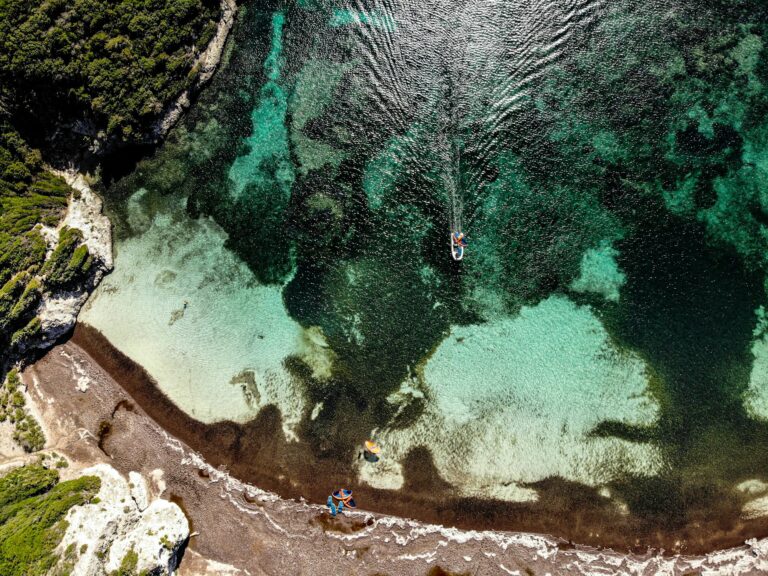 Boat, kayaks and snorkellers in a shallow turquoise sea